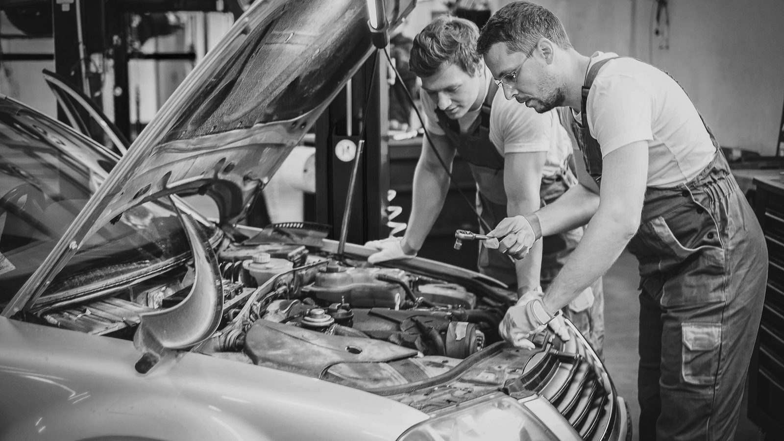 Zwei Mechaniker arbeiten gemeinsam am geöffneten Motorraum